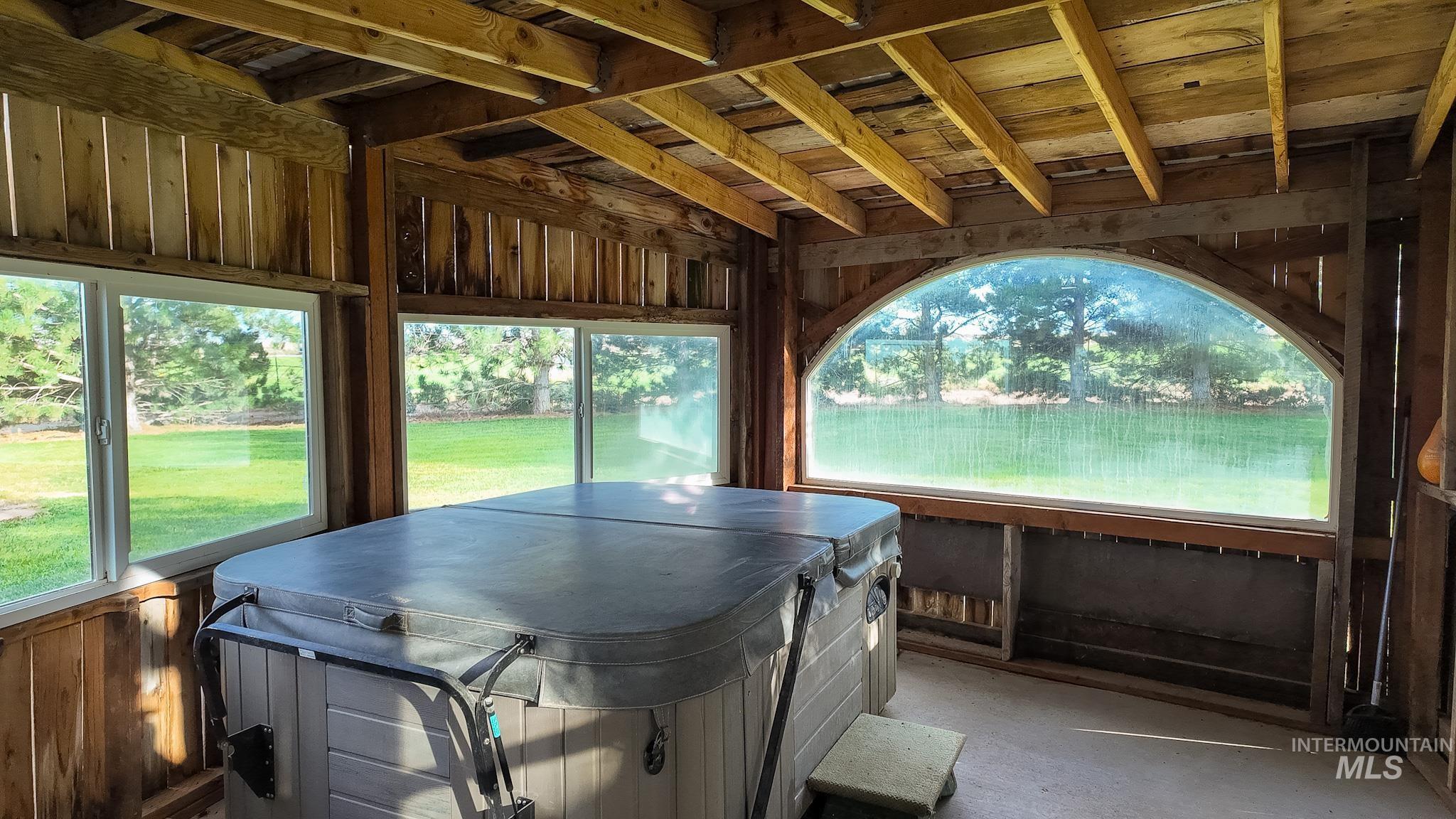 Sunroom / solarium featuring a hot tub and plenty of natural light