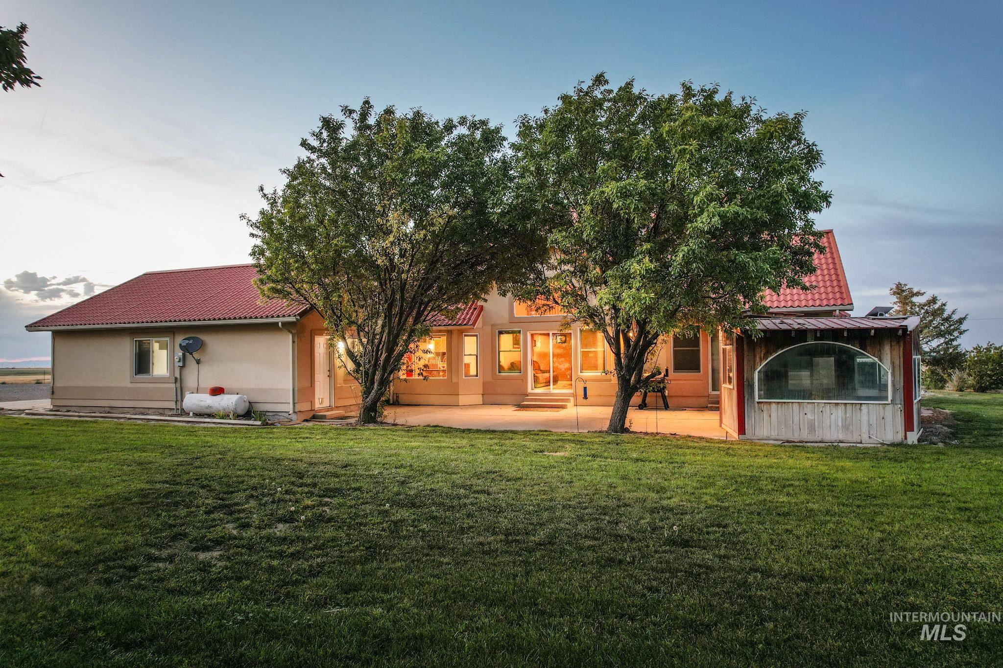 Rear view of property featuring a tile roof and a yard