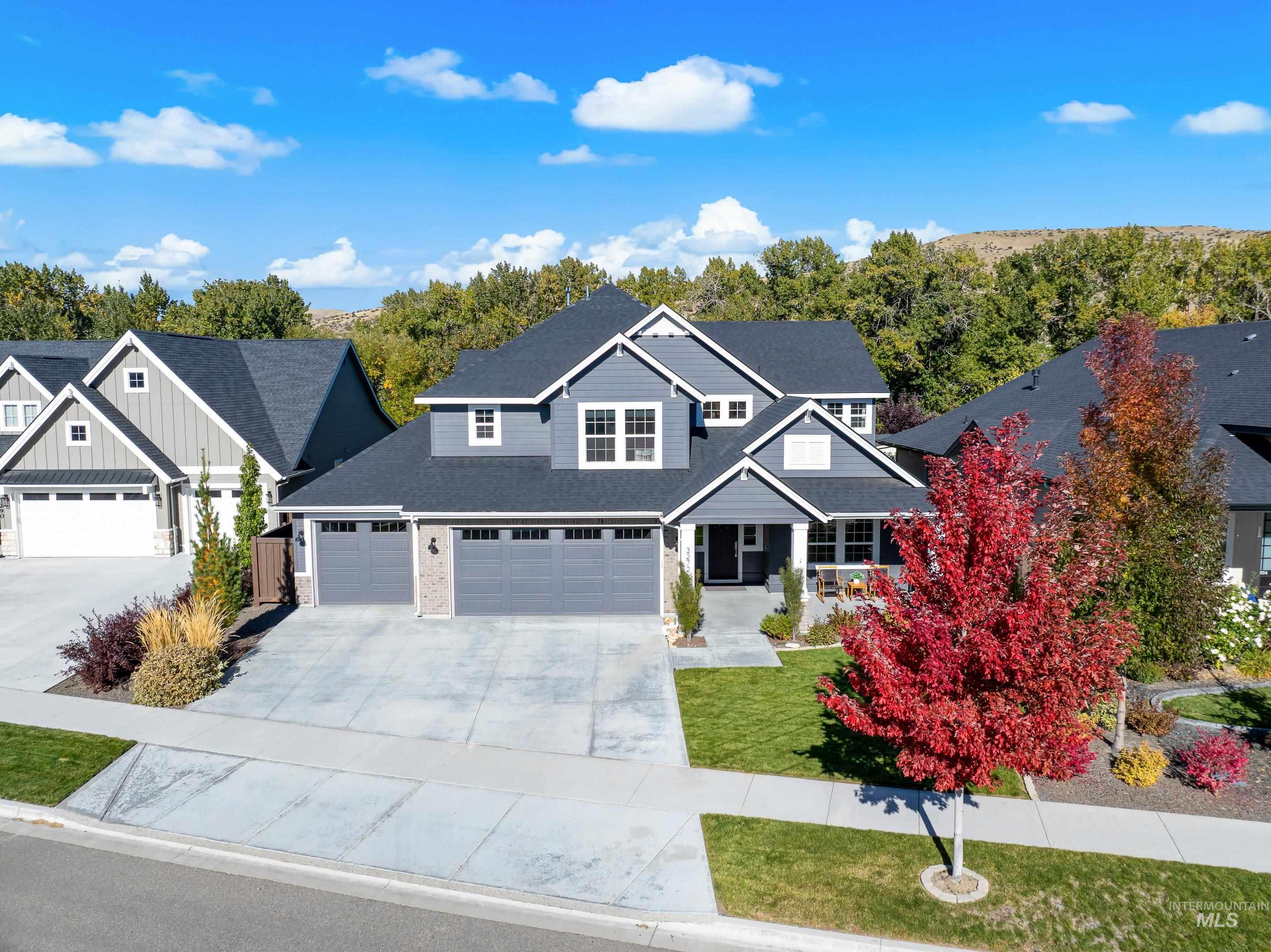 Craftsman-style house featuring concrete driveway, board and batten siding, a front yard, roof with shingles, and an attached garage