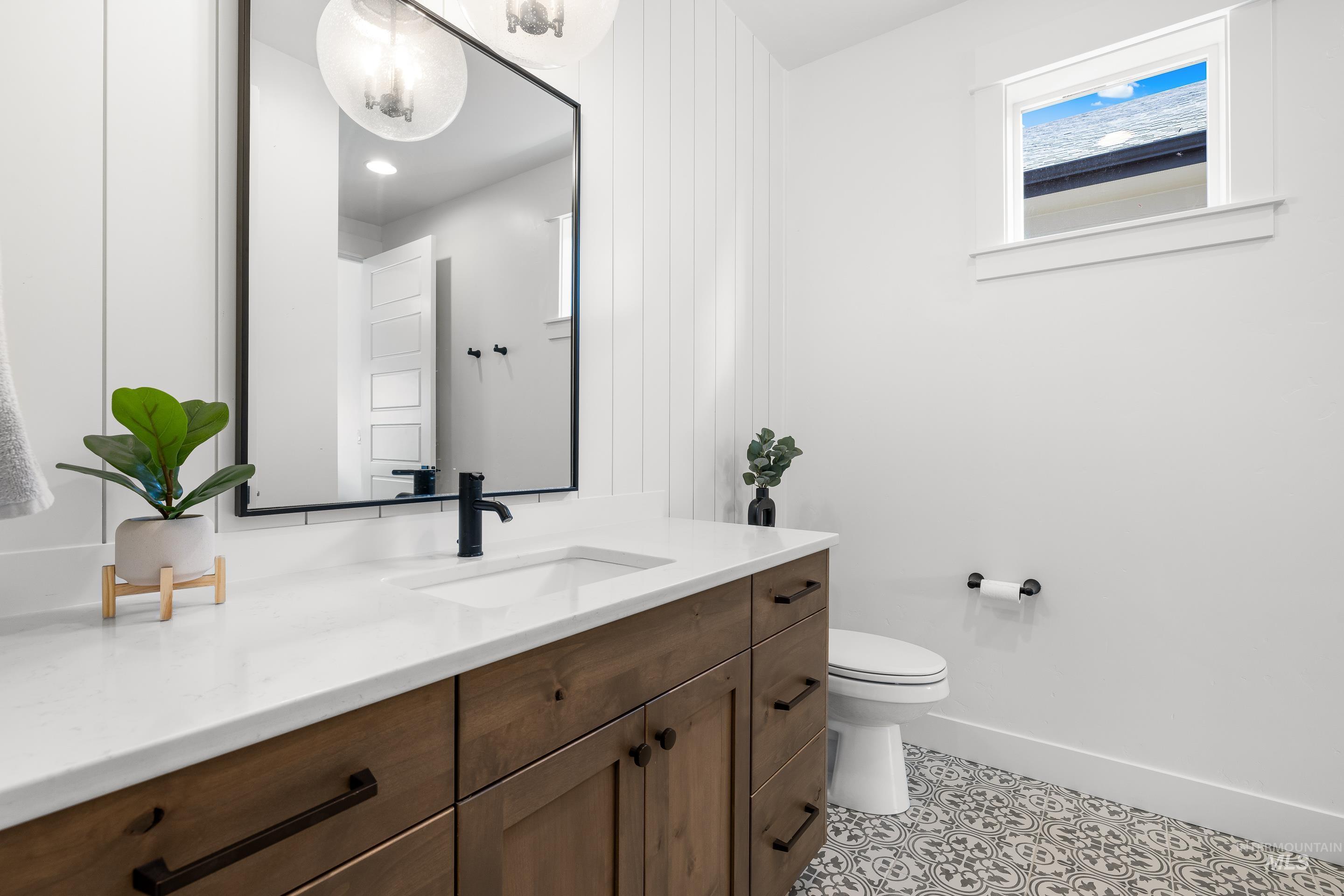 Half bathroom featuring vanity and light tile patterned flooring