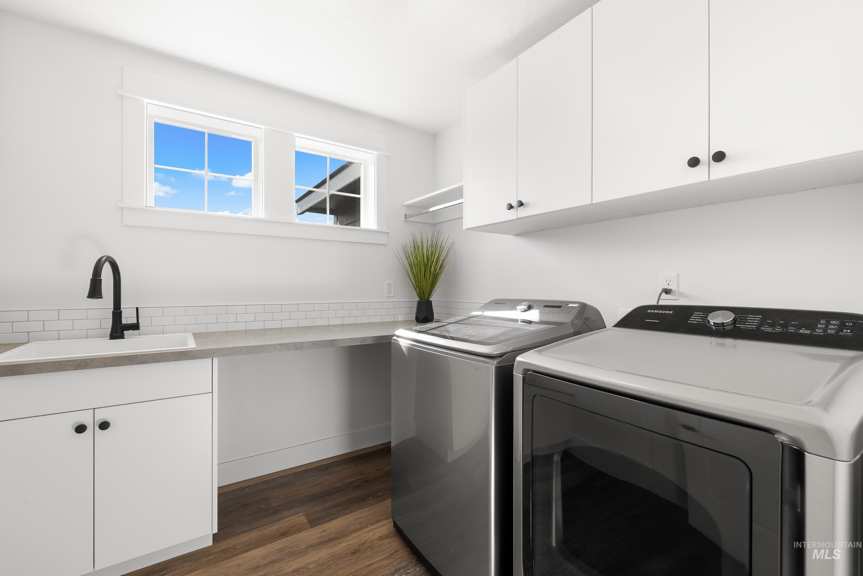 Laundry area featuring cabinet space, dark wood-style flooring, and independent washer and dryer
