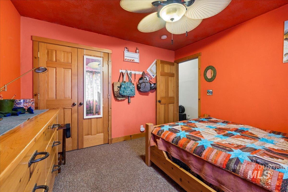Bedroom featuring dark colored carpet and a ceiling fan