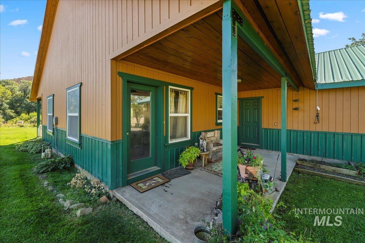 Entrance to property featuring a lawn and a metal roof