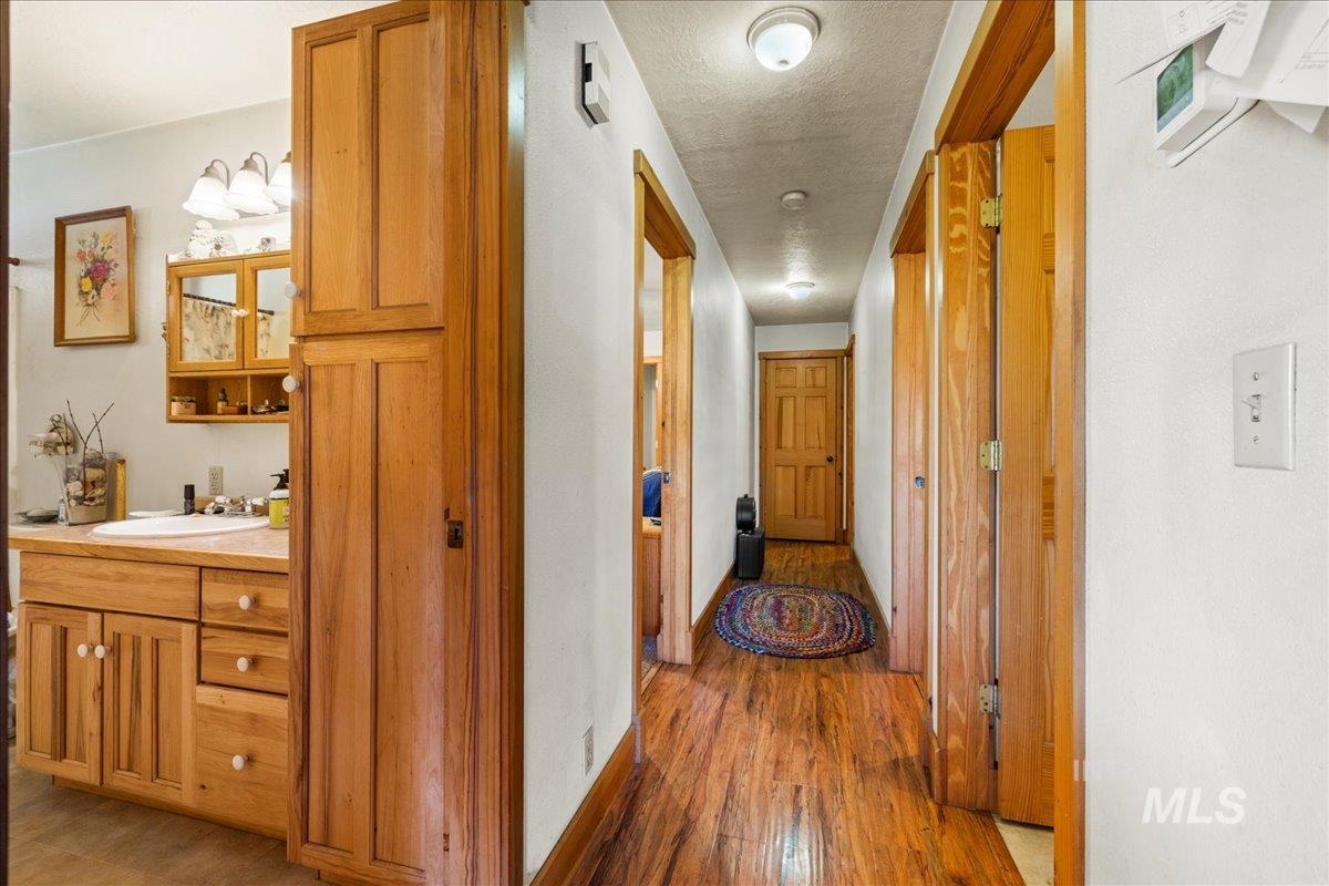 Corridor featuring light wood-style flooring and a textured ceiling
