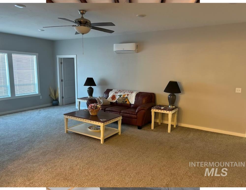 Carpeted living area featuring a ceiling fan, recessed lighting, and a wall mounted AC