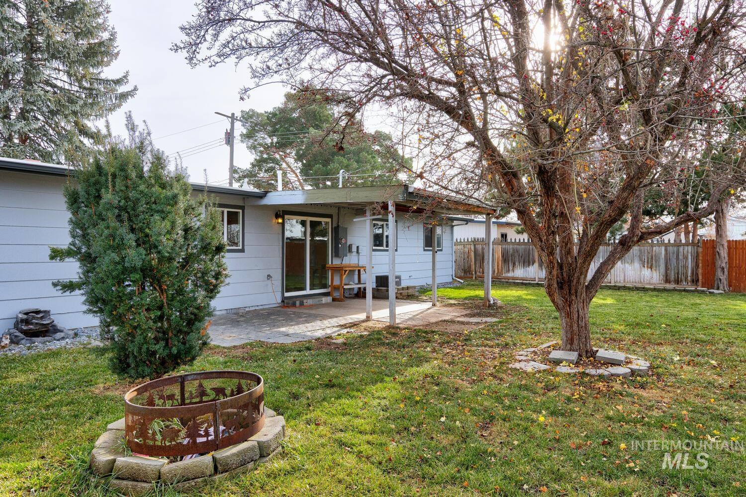 Back of house with a fenced backyard and a patio area