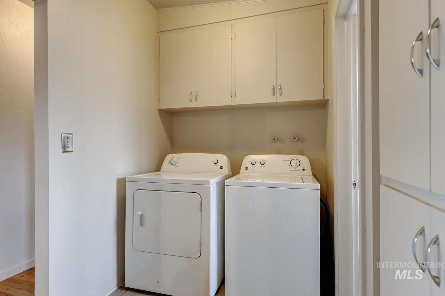 Washroom featuring cabinet space and washing machine and clothes dryer