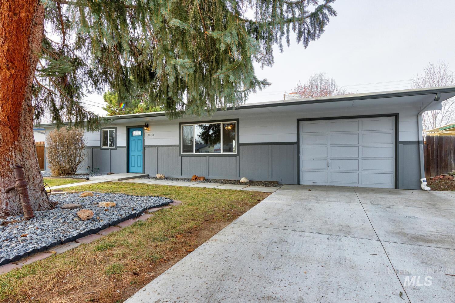Single story home featuring concrete driveway and a garage