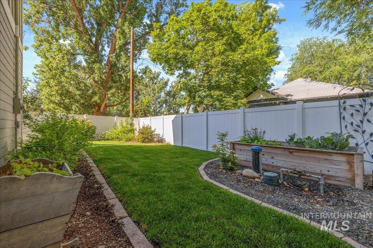 Fenced backyard featuring a garden