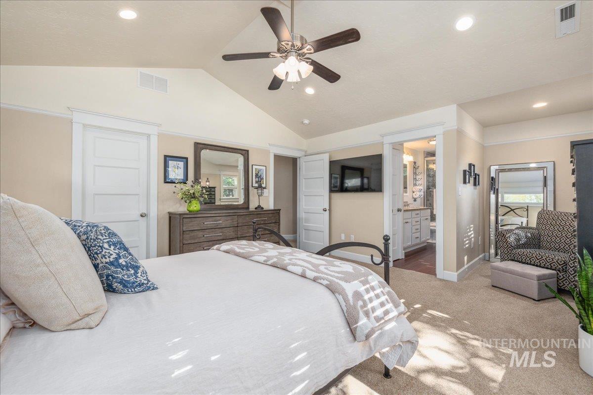 Carpeted bedroom featuring vaulted ceiling, recessed lighting, and a ceiling fan