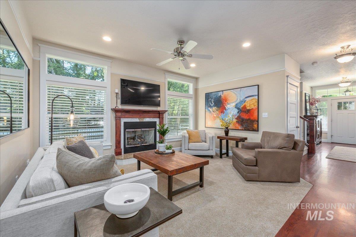 Living area featuring wood finished floors, ceiling fan, a fireplace, and recessed lighting