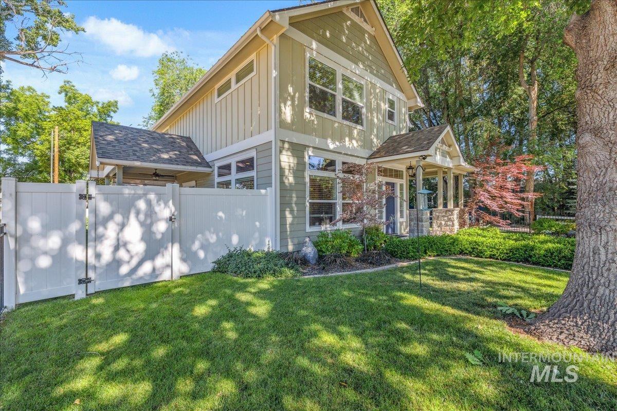 View of front of home with board and batten siding, a gate, and a shingled roof