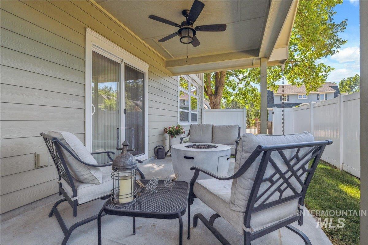 View of patio with ceiling fan and an outdoor fire pit