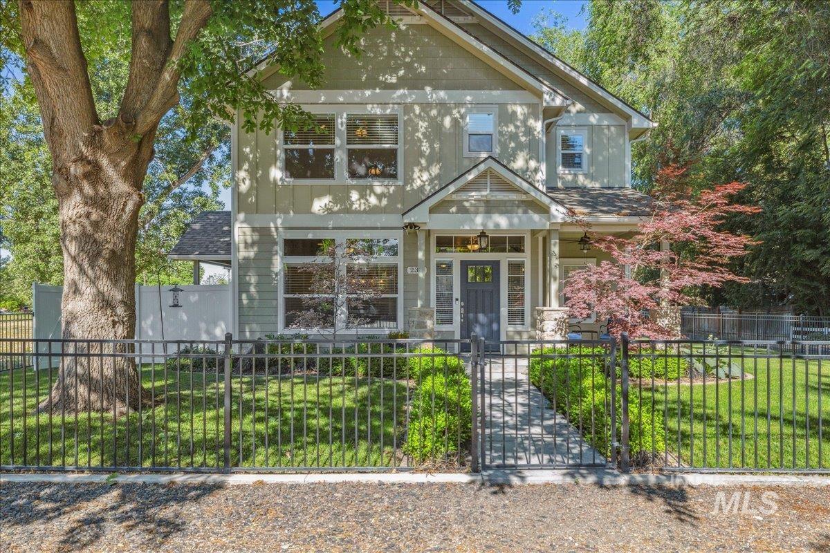 View of front of house featuring a fenced front yard, a gate, and covered porch