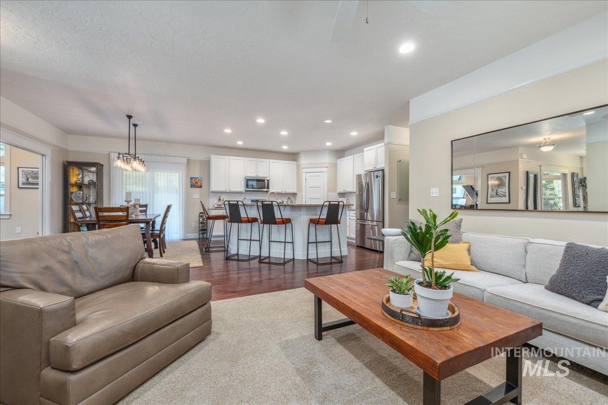 Living area featuring recessed lighting, dark wood finished floors, a chandelier, and a textured ceiling