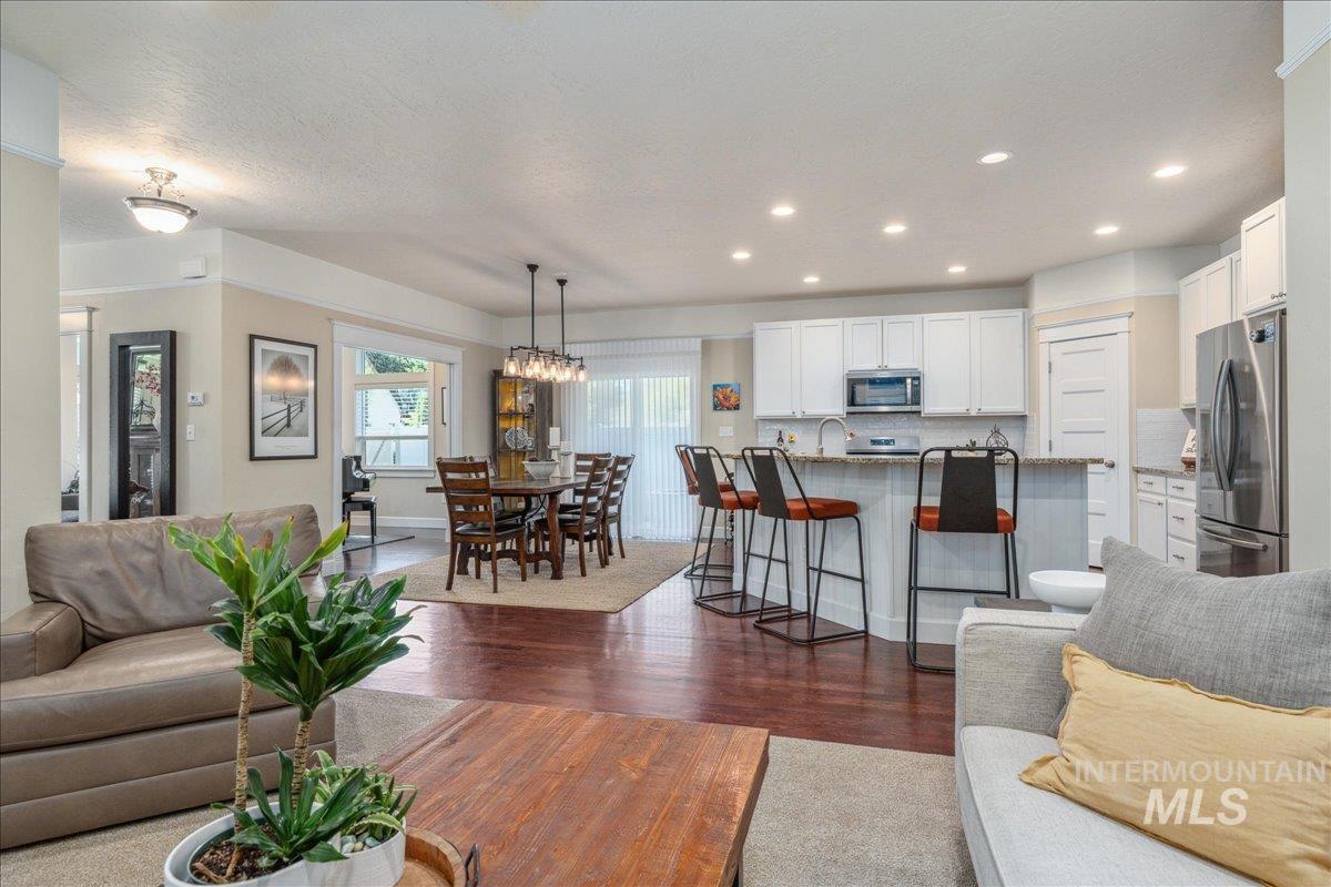 Living area with dark wood finished floors, a chandelier, and recessed lighting