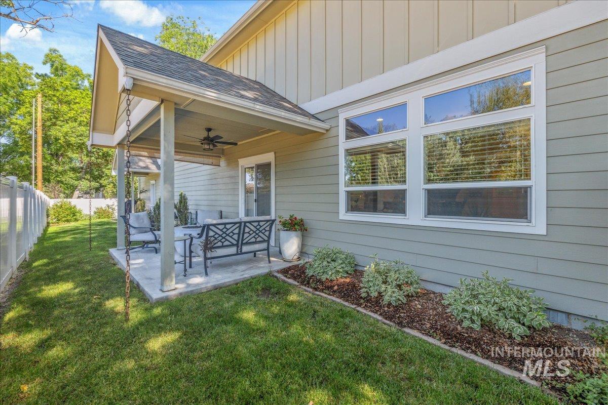 Back of house featuring a patio area, board and batten siding, roof with shingles, and ceiling fan