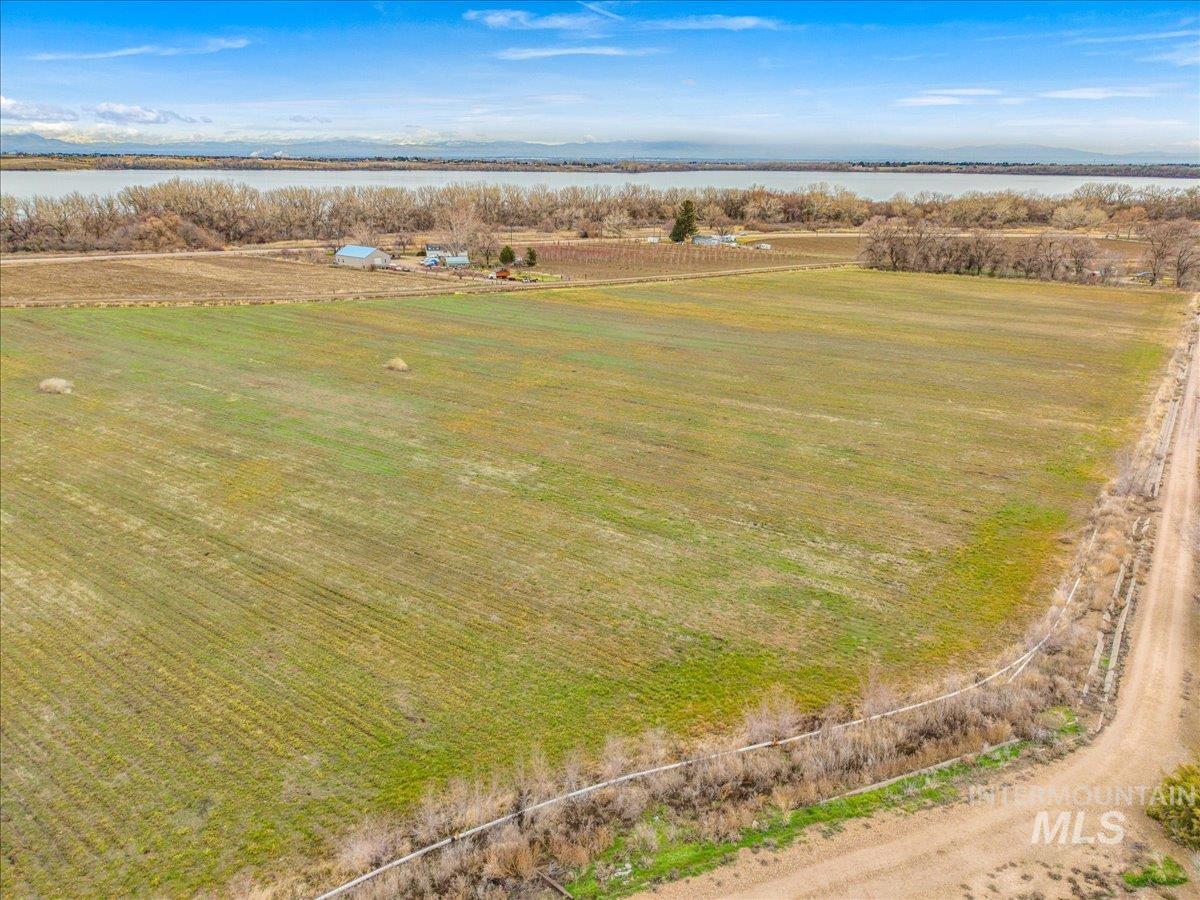Aerial view of sparsely populated area featuring a large body of water and large plots for crops