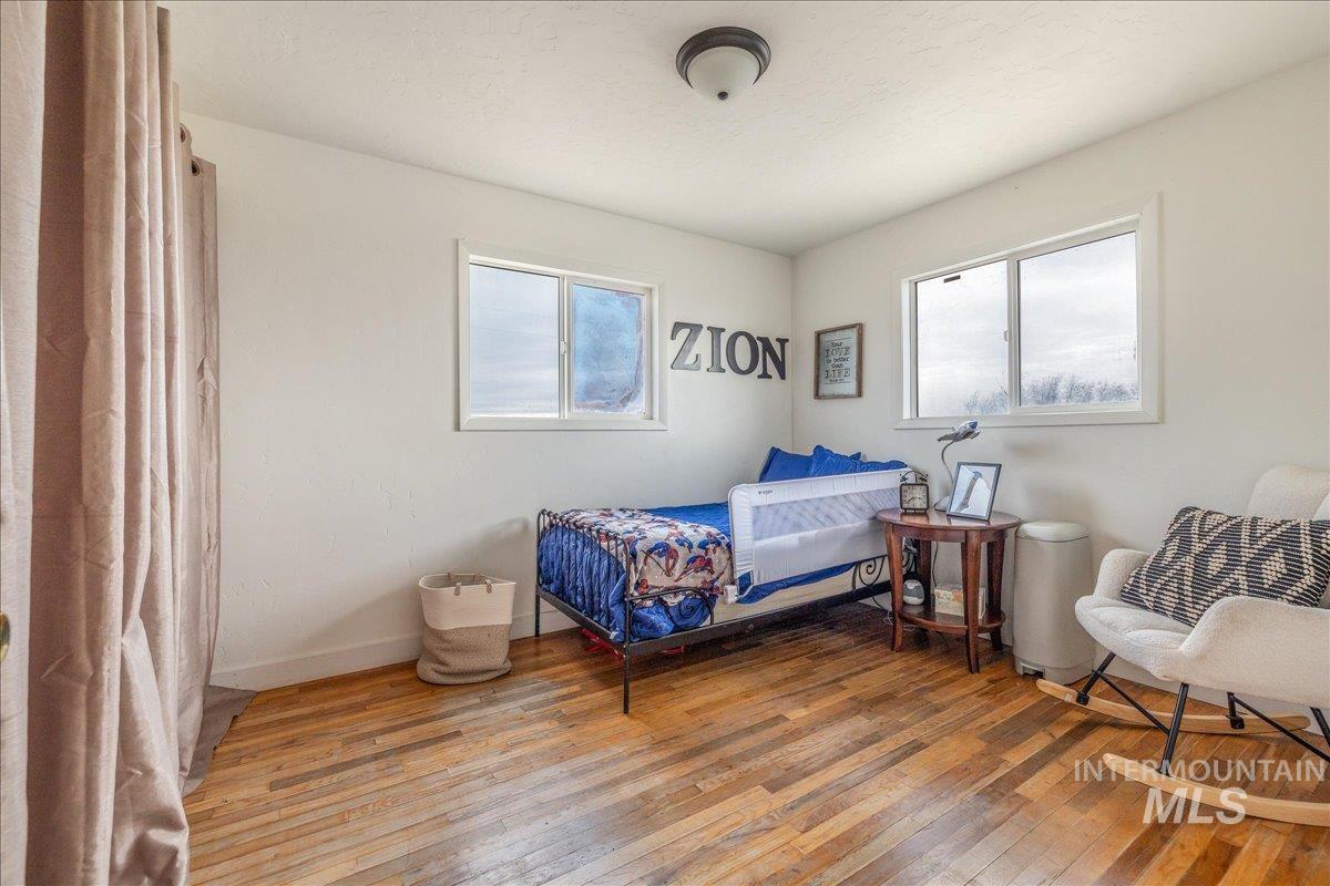 Bedroom featuring light wood-style floors and multiple windows