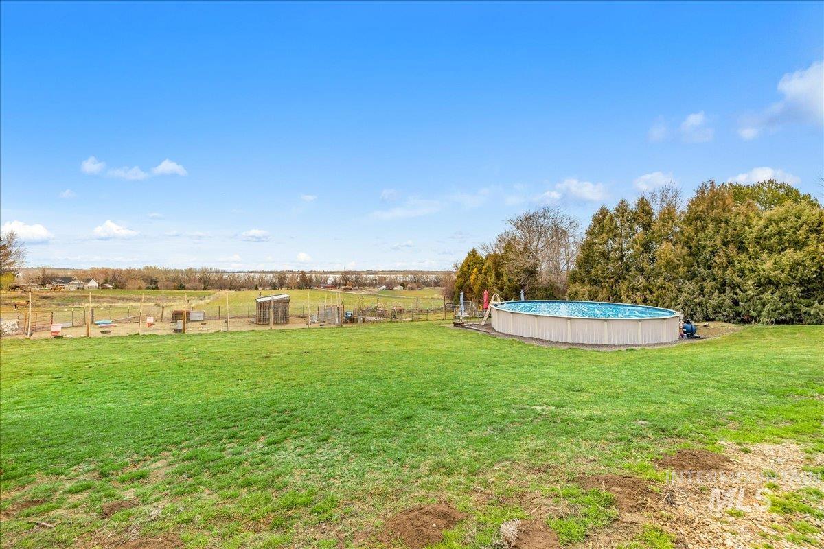 View of yard with an outdoor pool and a view of countryside