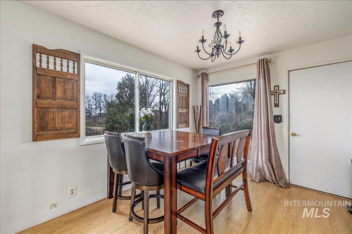 Dining area with light wood-style flooring, hanging lights, and a textured ceiling