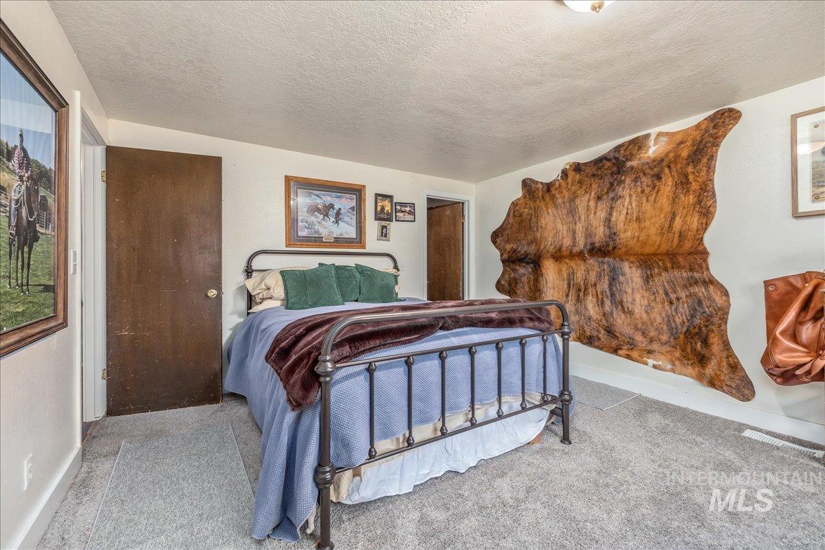 Bedroom featuring a textured ceiling and light colored carpet