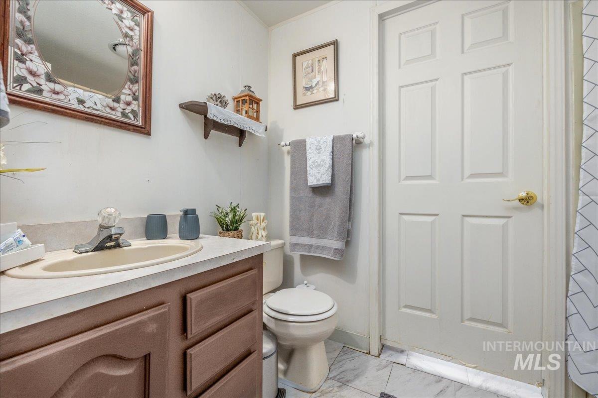 Half bath featuring vanity and light marble finish flooring