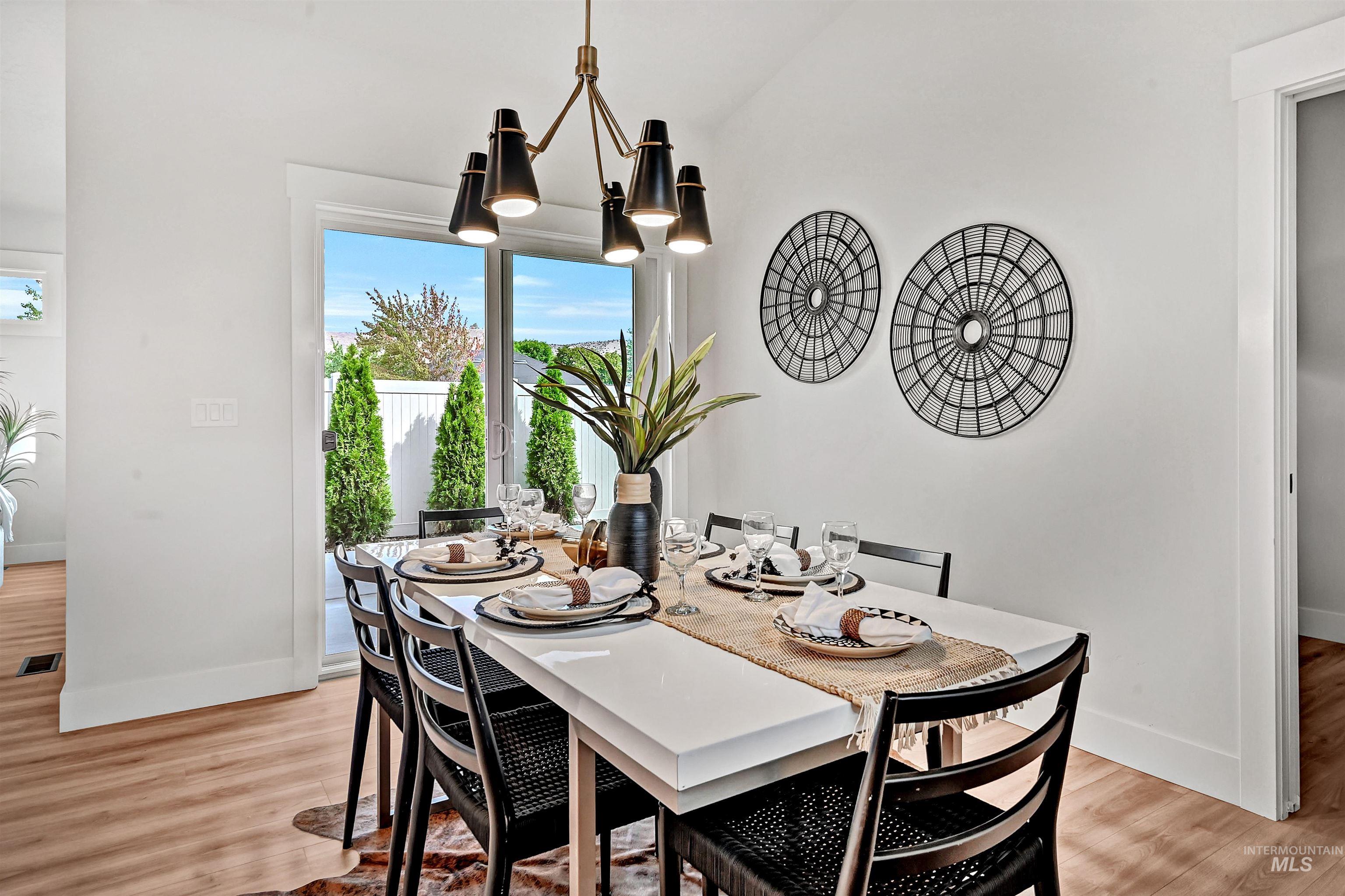 Dining area with light wood-style floors and a chandelier