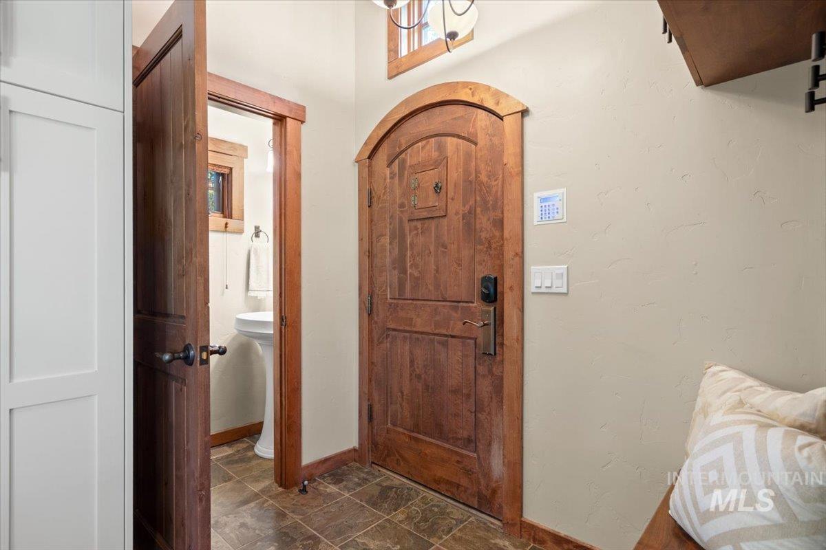 Custom arched wooden door with iron hardware, complemented by a light-colored wall finish