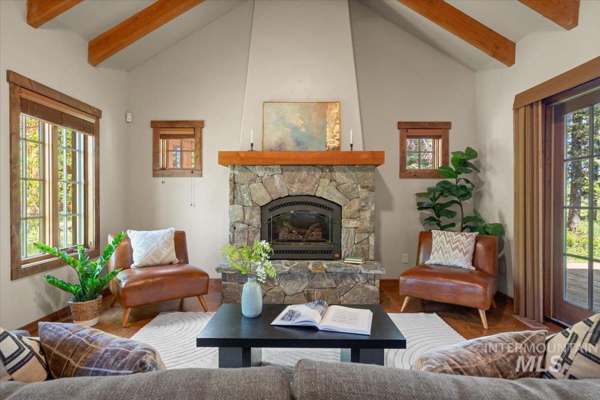 Stone fireplace with a wood mantle, flanked by two windows and a glass-paned door