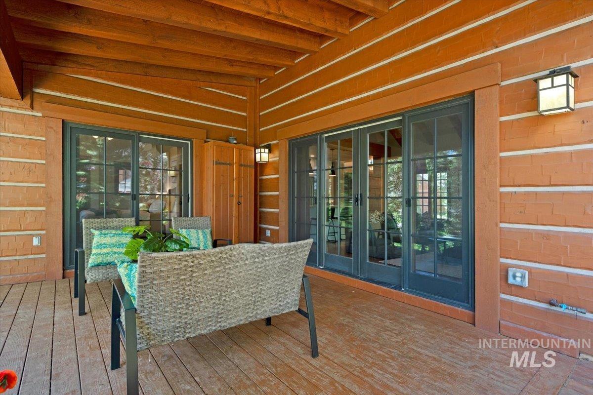 Spacious covered porch with wood-finish decking and exposed wood ceiling beams