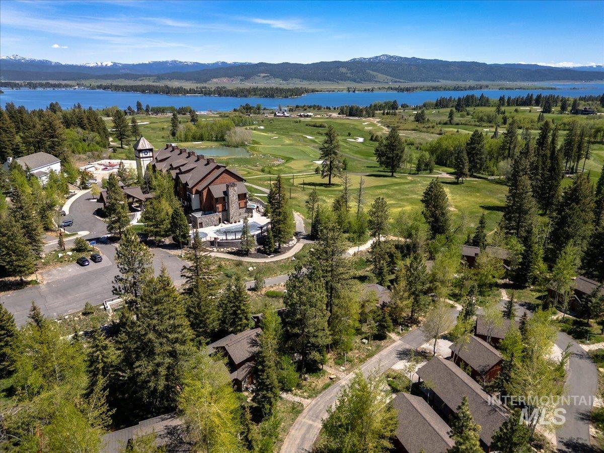 Expansive property featuring a multi-building complex with stone and wood siding, a resort-style swimming pool, and a golf course