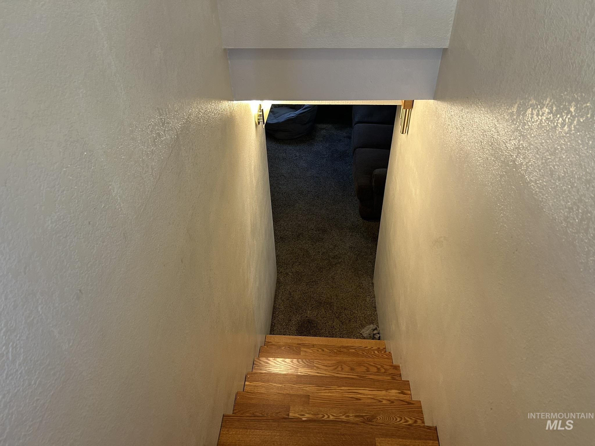 Staircase featuring a textured wall