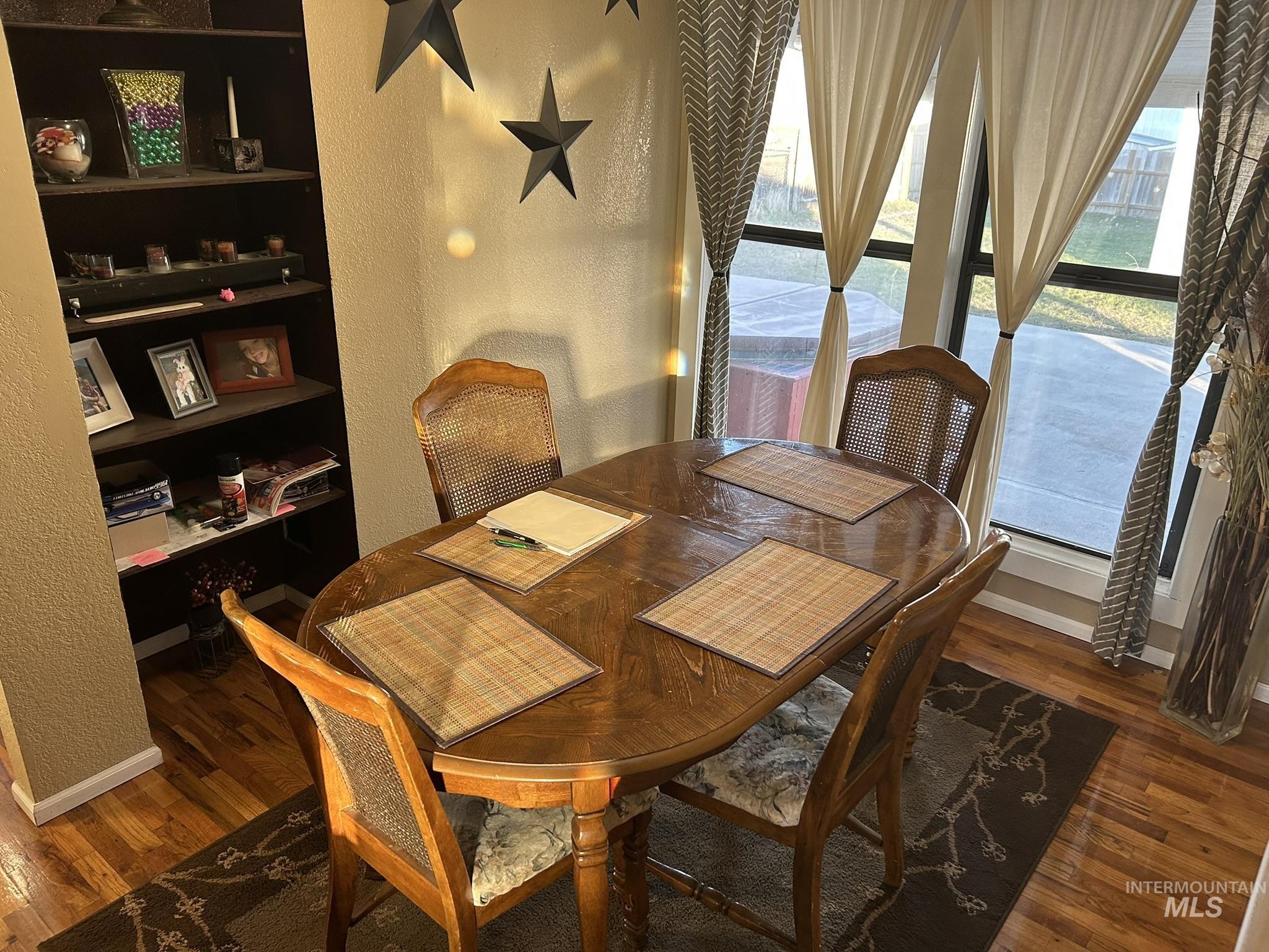 Dining room featuring a textured wall, dark wood finished floors, and built in features