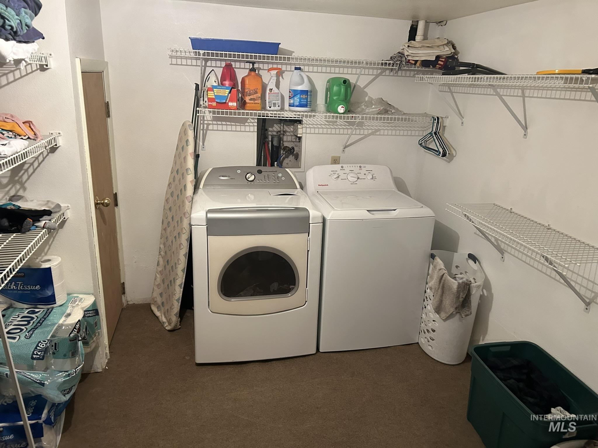 Washroom featuring dark colored carpet and separate washer and dryer
