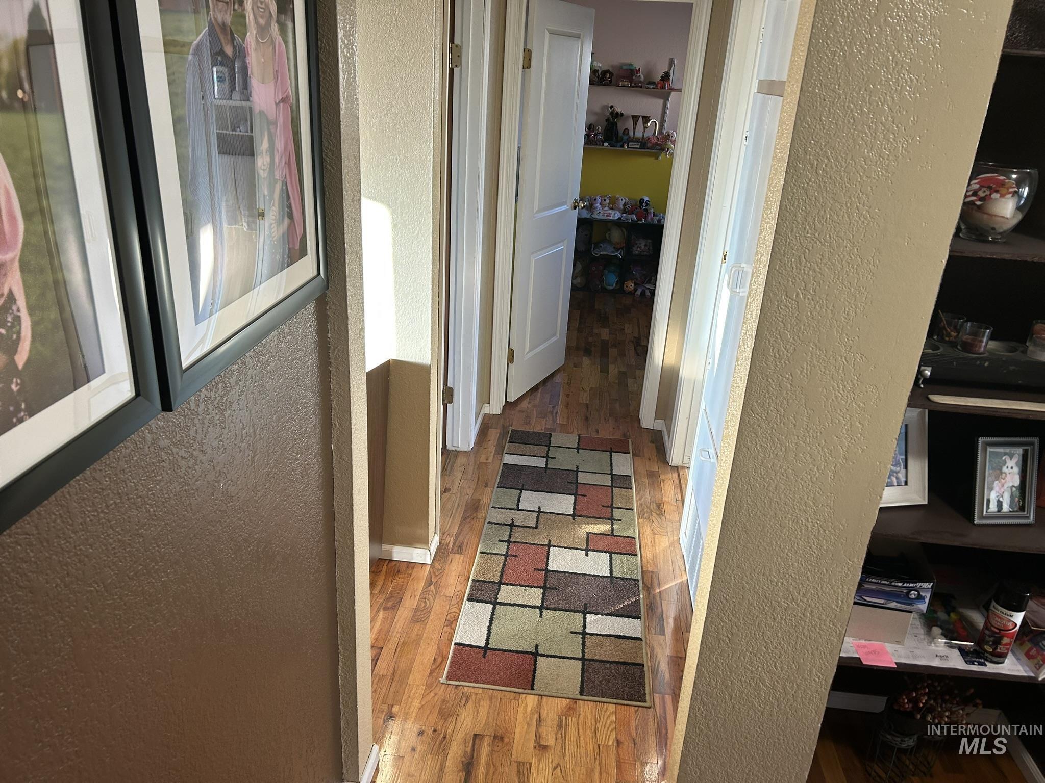 Hallway with a textured wall and light wood-style floors