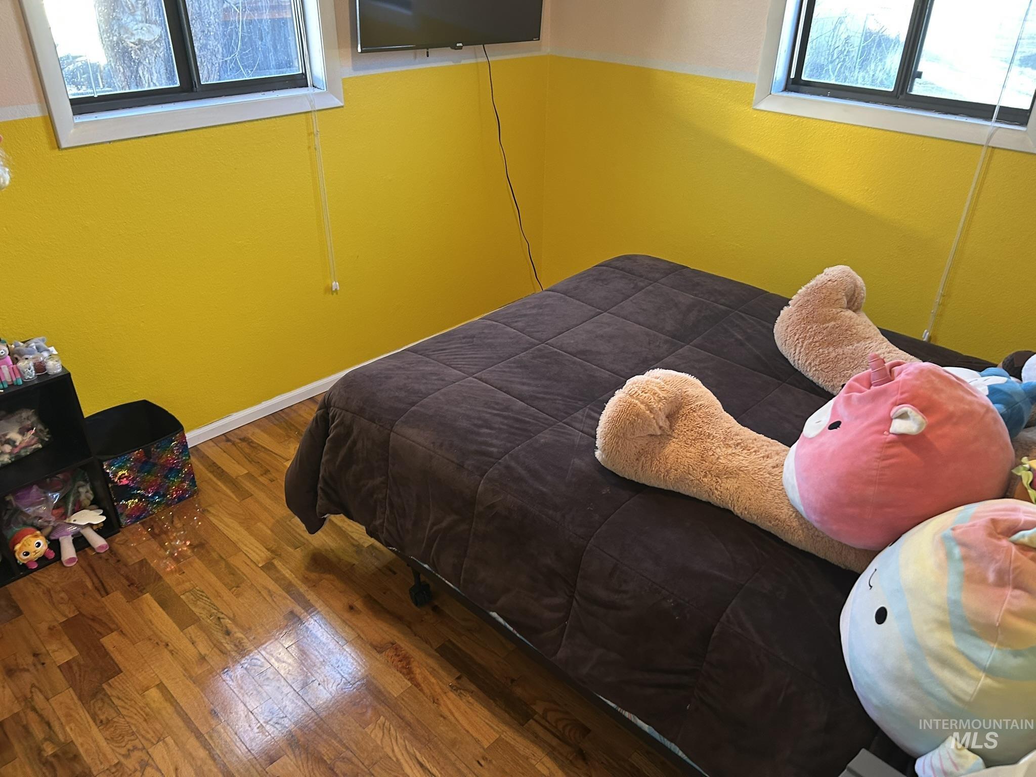 Bedroom with multiple windows and hardwood / wood-style flooring