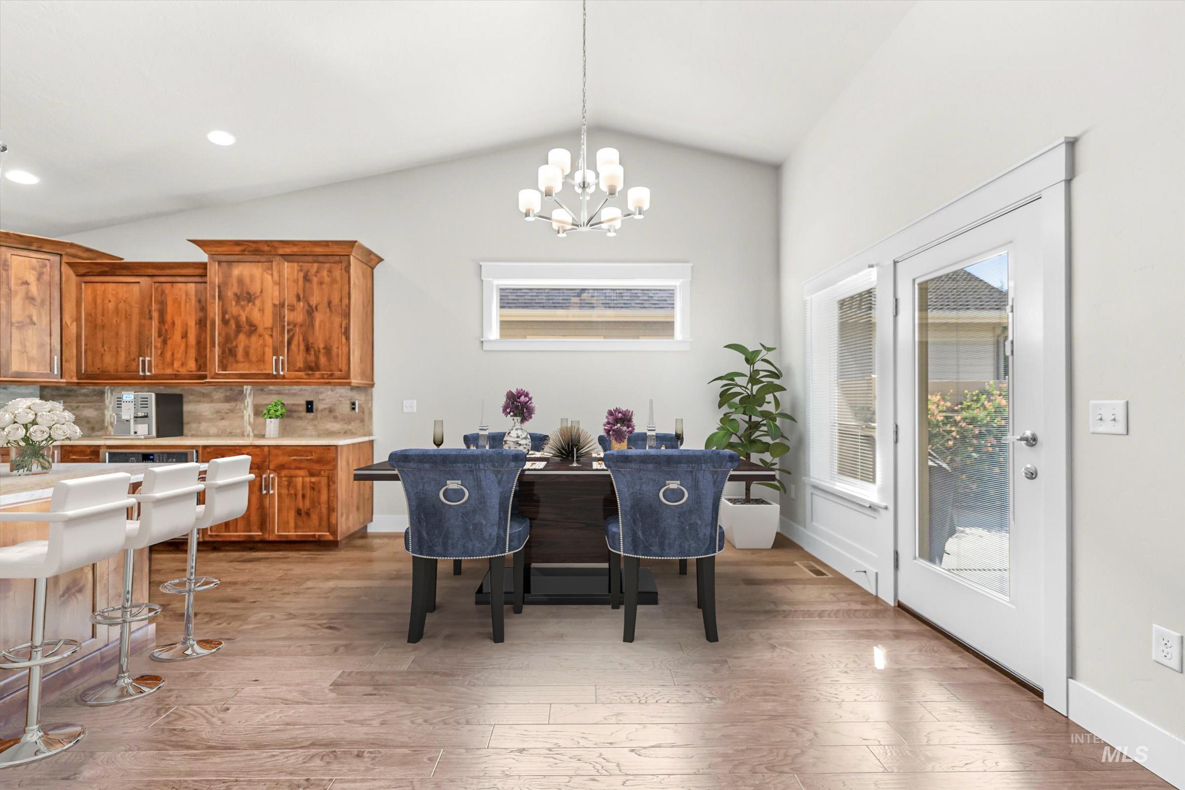 Dining area featuring vaulted ceiling, light wood-style floors, a chandelier, and recessed lighting