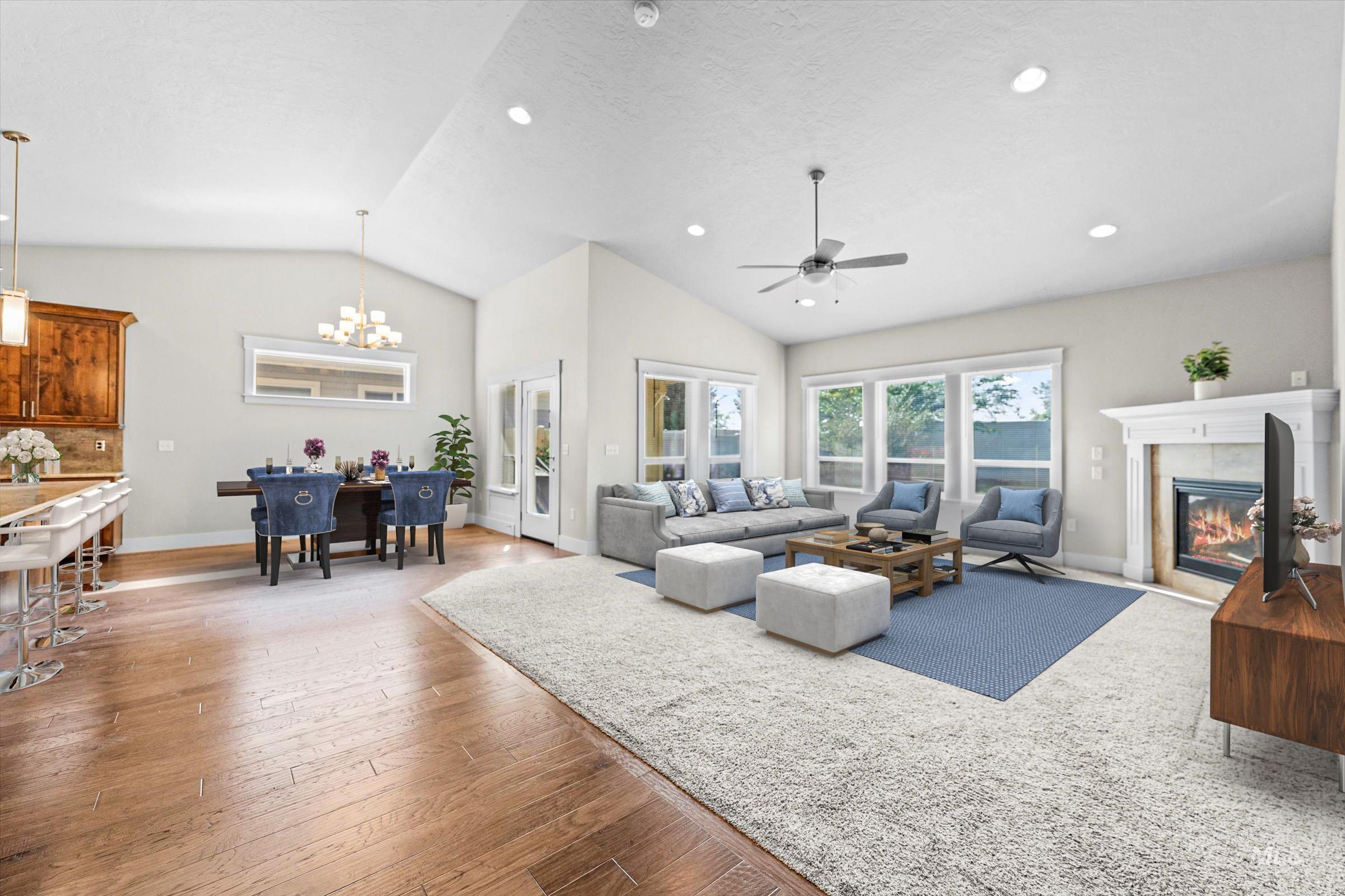 Living room with a fireplace, vaulted ceiling, light wood-style flooring, recessed lighting, and a chandelier