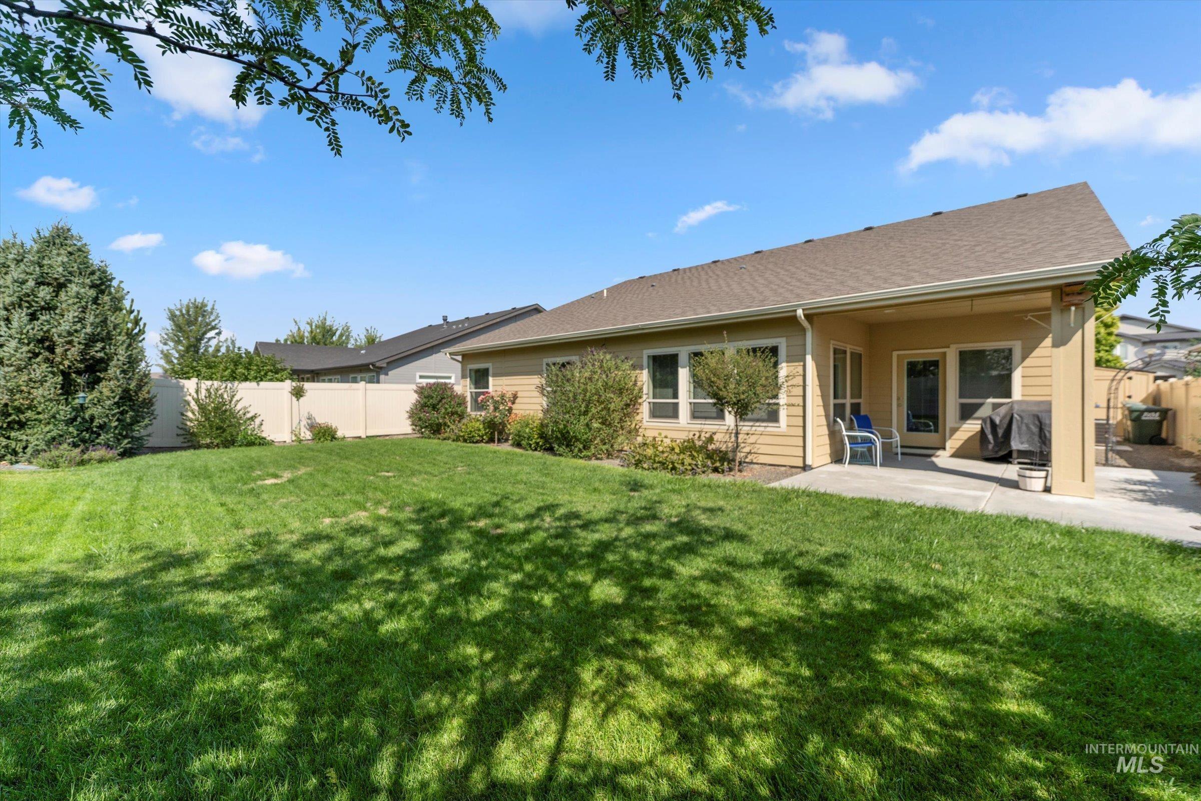 Rear view of property featuring a patio area and a shingled roof