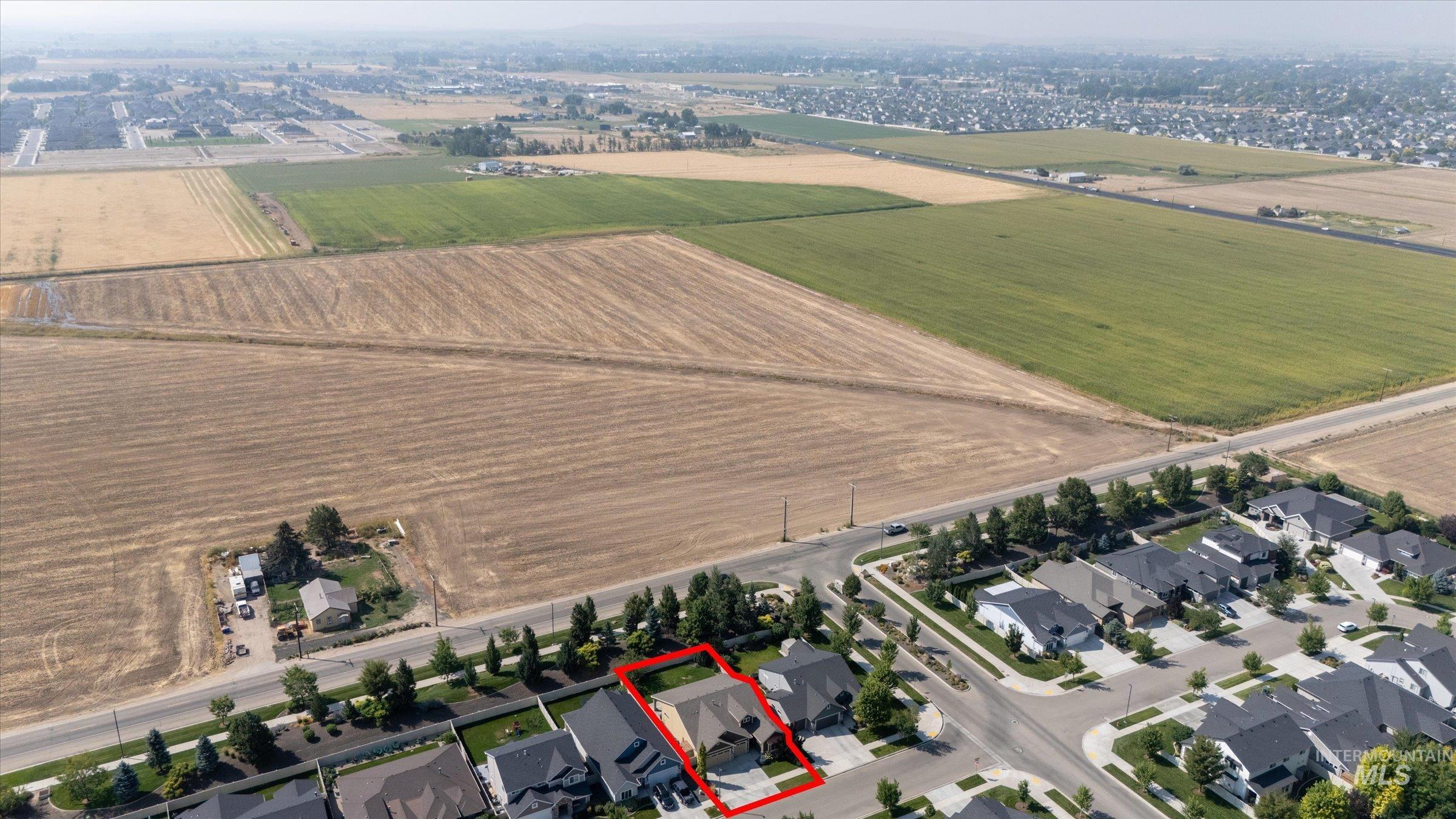 Aerial view of property's location featuring property boundaries highlighted, nearby suburban area, and rural landscape