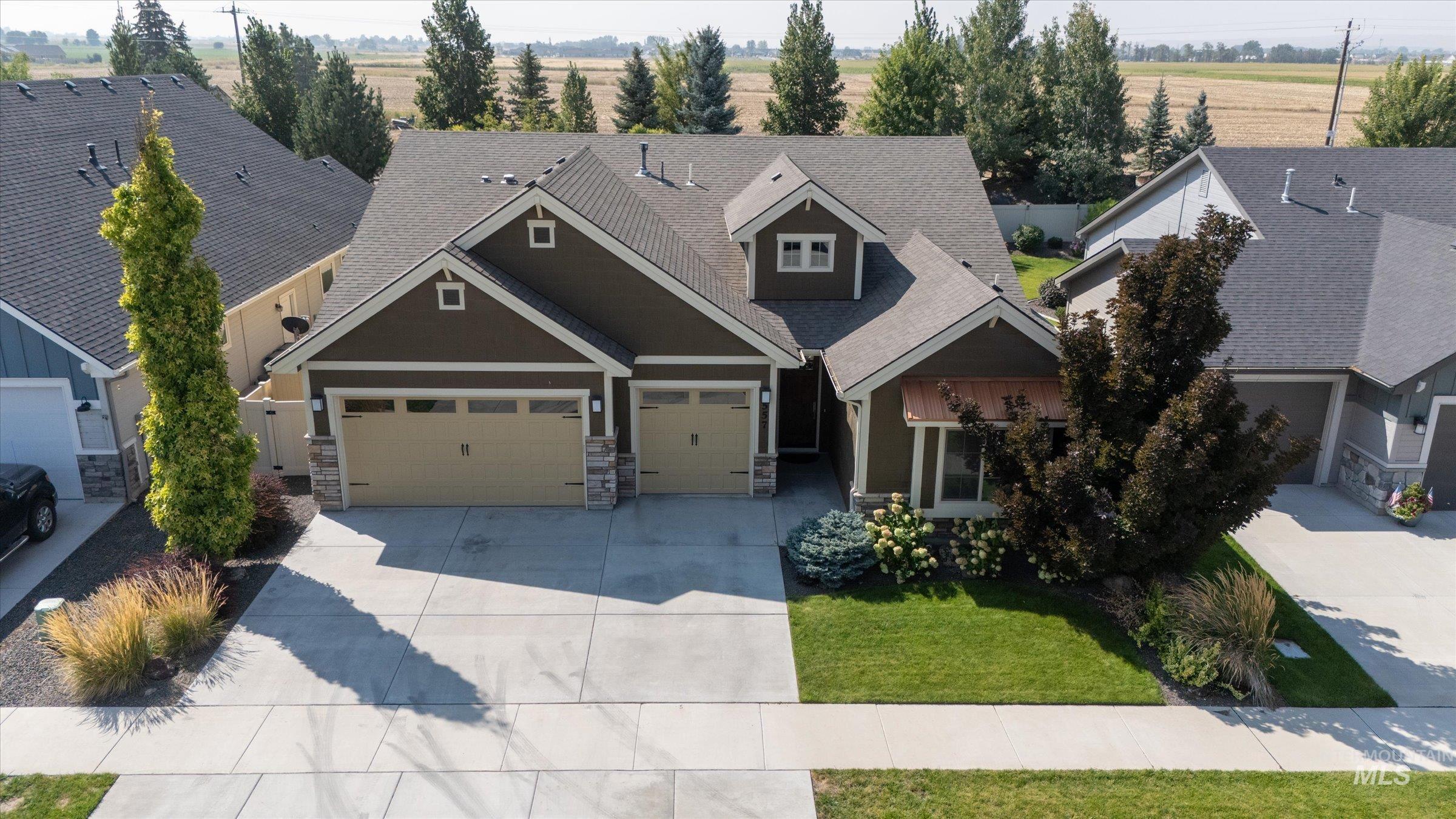 Craftsman inspired home with concrete driveway, roof with shingles, a garage, and a front lawn