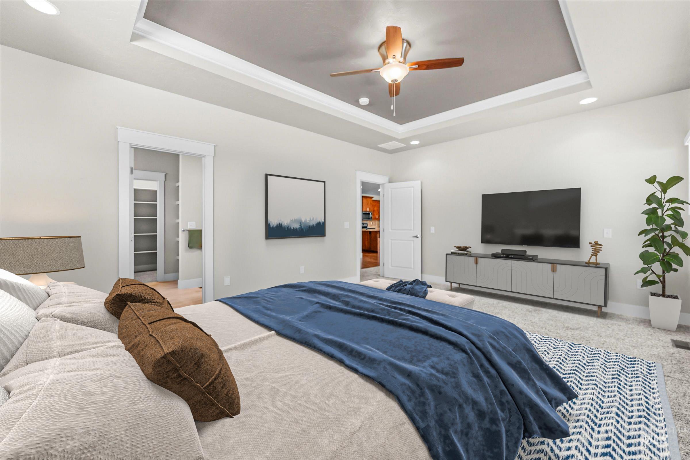 Carpeted bedroom featuring a tray ceiling, recessed lighting, and a ceiling fan