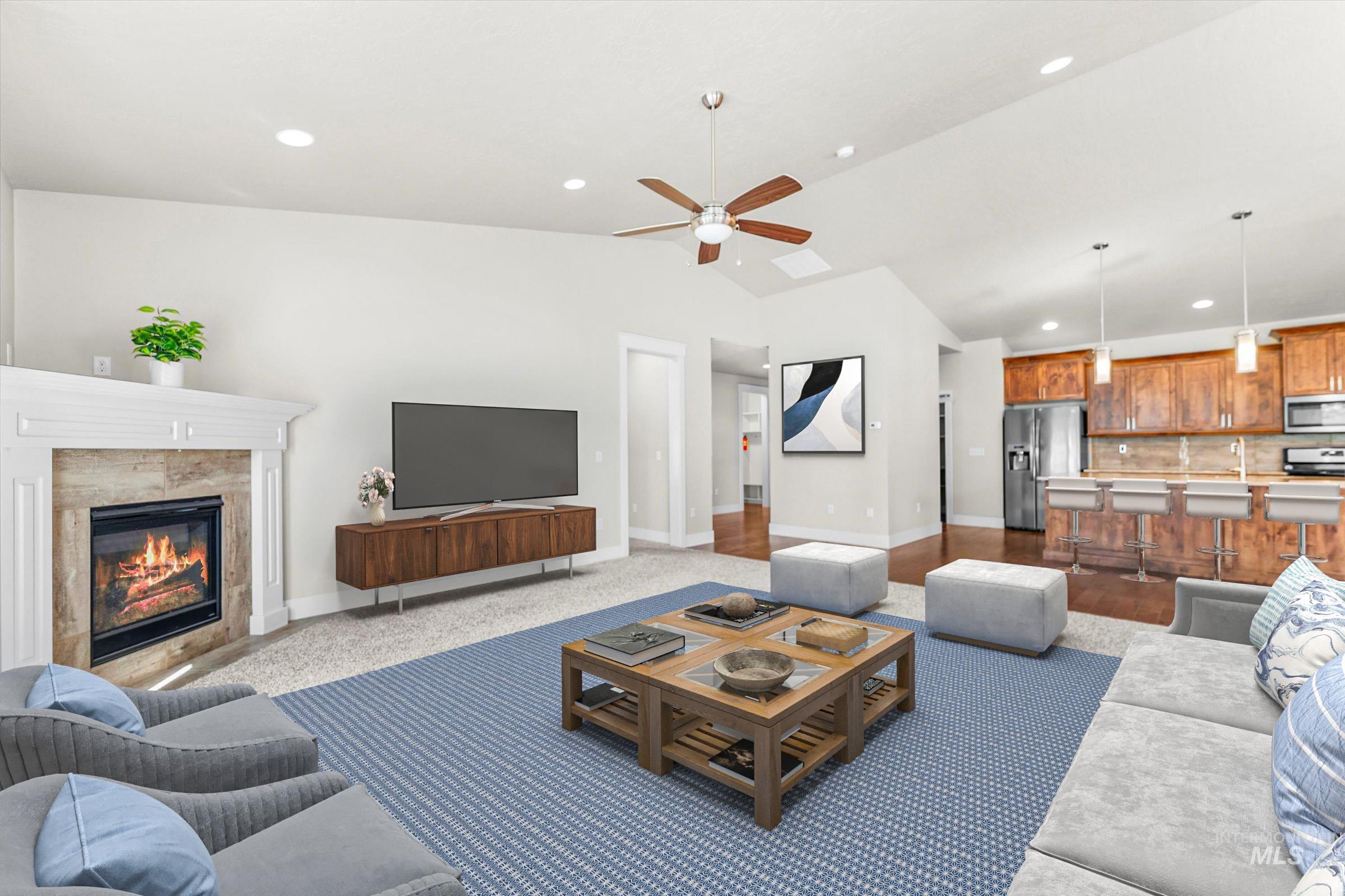 Living room with lofted ceiling, recessed lighting, a tile fireplace, and ceiling fan