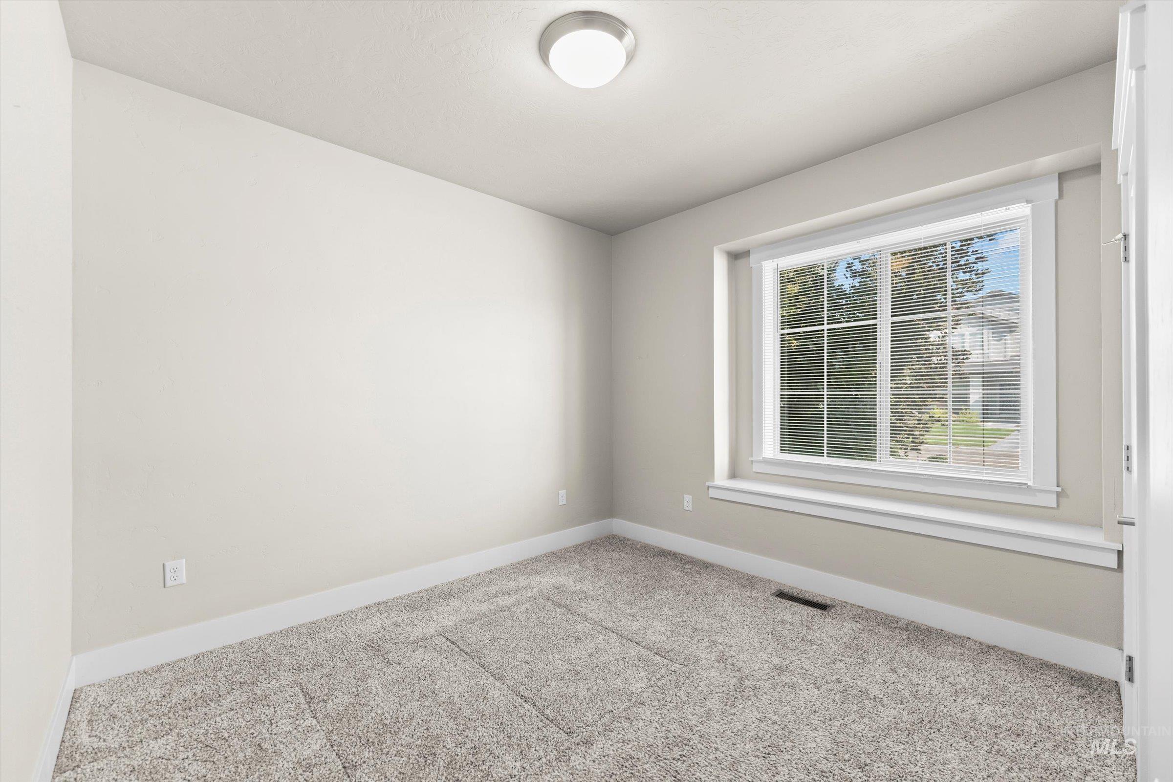 Empty room with carpet flooring and baseboards
