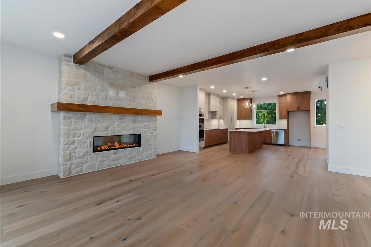 Spacious interior showcasing wood-finish flooring and exposed wood beams