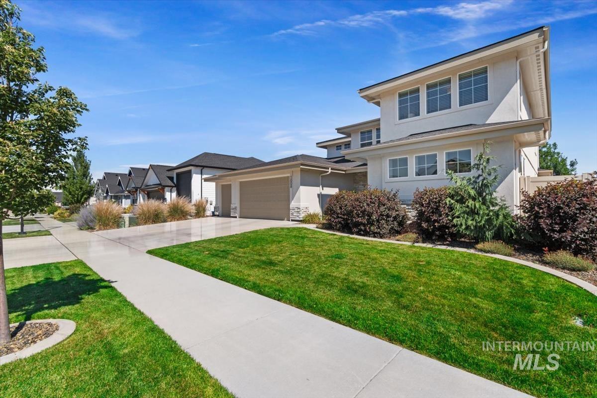 Contemporary architectural style featuring a multi-level design, smooth stucco exterior, and a dark shingle roof