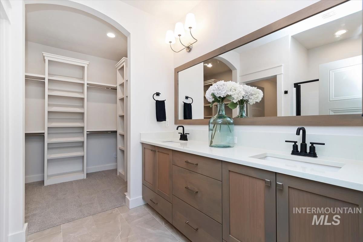Double vanity with integrated sinks, matte black fixtures, and a spacious mirror