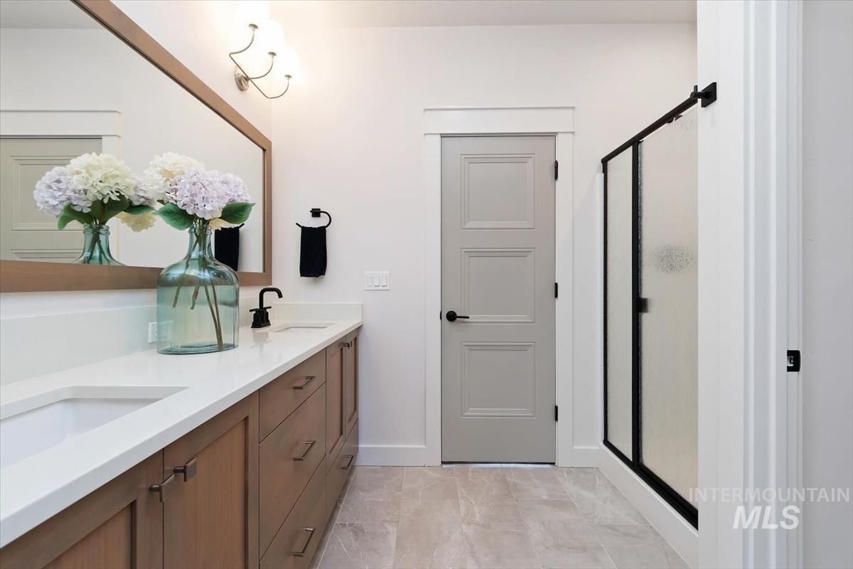 Dual vanity featuring warm wood-finish cabinetry and white countertops