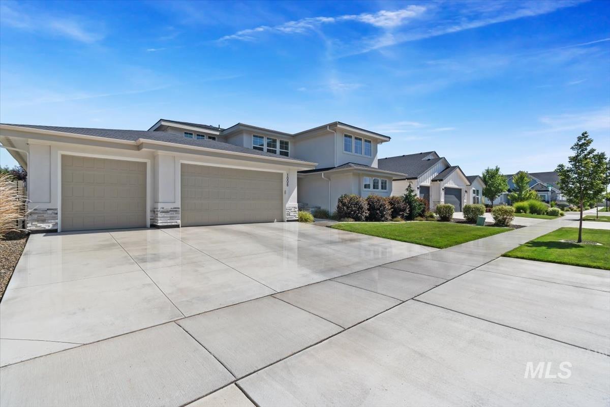 Contemporary two-story residence featuring a two-car garage with panel doors and a stone facade